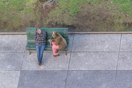MONTEVIDEO, URUGUAY, AUGUST - 2015 - High angle view of a adult couple sitting on chair at the independence square in Montevideo, the capital of Uruguay.のeditorial素材