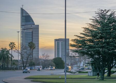 Nice view at sunset of avenue, a park and modern buildings at background in Montevideo, the capital...