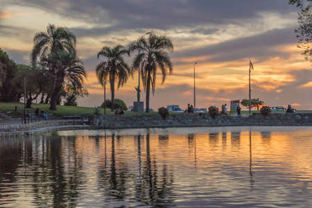 Beautiful sunset urban scene at Parque Rodo park with the coast and cloudy orange and blue sky at background in Montevideo, Uruguay.の写真素材