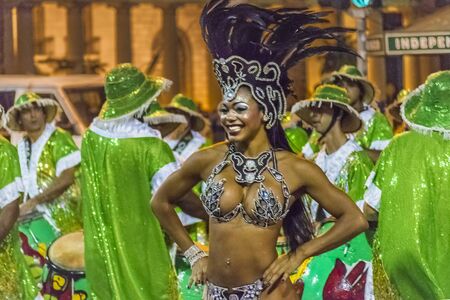 MONTEVIDEO, URUGUAY, JANUARY - 2016 - Attractive costumed young black woman dancing and candombe drummers at inagural parade of carnival of Montevideo, Uruguayのeditorial素材