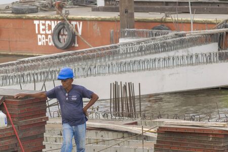 GUAYAQUIL, ECUADOR - OCTOBER - 2015 - Old man construction worker resting in a structure at guayas river in Guayaquil, Ecuador.のeditorial素材