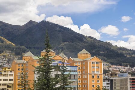 Day urban scene photo of modern buildings and big mountains at background in a district of Quito city, the capital of Ecuador in South Americaの写真素材