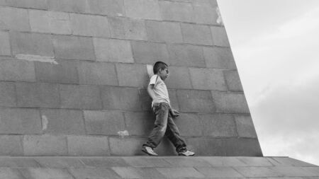QUITO, ECUADOR, OCTOBER - 2015 - Boy walking dangerously on the ledge of a building at the middle earth monument in Quito, Ecuadorのeditorial素材