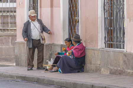 QUITO, ECUADOR, OCTOBER - 2015 - Traditional women street vendor and a senior man at historic center of Quito, Ecuador.のeditorial素材
