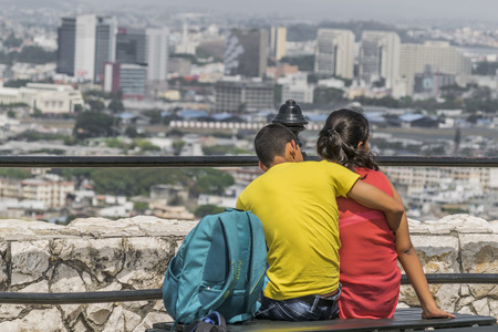 GUAYAQUIL, ECUADOR, OCTOBER -2015 - Back view of teen couple huggin at with at the top of a hill at Cerro Santa Ana in Guayaquil, Ecuador.のeditorial素材