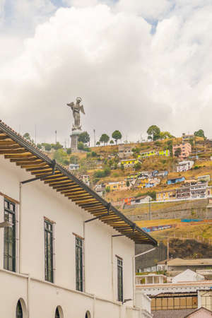 Low angle view of colonial classic style buildings and the famous panecillo hill at background in the historic center of Quito in Ecuador.のeditorial素材