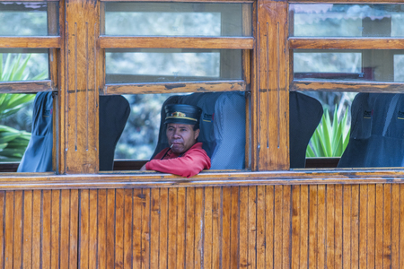 ALAUSI, ECUADOR, OCTOBER - 2015 - Adult train driver sitting at interior of touristic train in Alausi, Ecuadorのeditorial素材