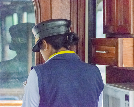 ALAUSI, ECUADOR, OCTOBER - 2015 - Train officer woman using his smartphone at interior of touristic train in Alausi, Ecuadorのeditorial素材