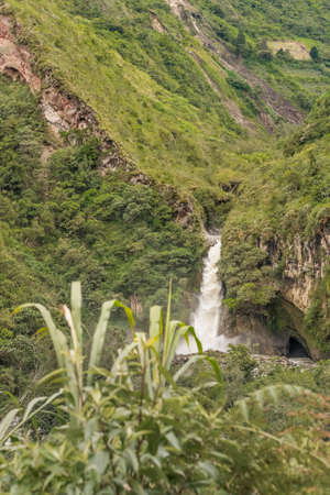 Landscape scene with cascade at the middle of tropical forest in Banos, a touristic place located in Ecuador, South America.の写真素材