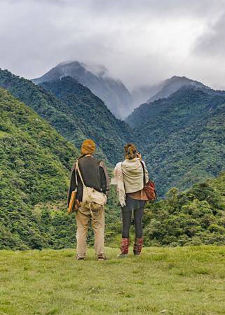 BANOS, ECUADOR, OCTOBER - 2015 - Photo collage of young backpakers couple watching the leafy mountains landscapeのeditorial素材