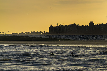 Backlight sunset scene of beach and skyline at background in Montevideo, Uruguayの写真素材