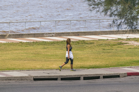 MONTEVIDEO, URUGUAY, DECEMBER - 2015 - Adult woman with sports wear walking at boardwalk in Montevideo, Uruguayのeditorial素材