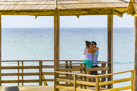 SALINAS, ECUADOR, OCTOBER - 2015 - Young couple kissing at La chocolatera, a famous nature viewpoint towars the pacific ocean located at rocky coast in Salinas, Ecuadorのeditorial素材