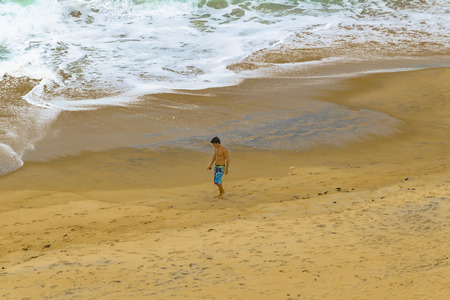PIPA, BRAZIL, JANUARY - 2016 - Top view shot of young man walking at empty beach in Pipa, Brazilのeditorial素材