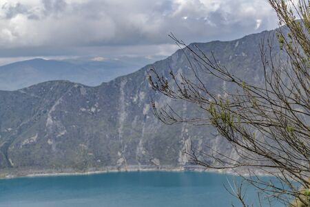 Quilotoa lake and andes range mountain against overcast cloudy background landscape scene, Ecuadorの写真素材