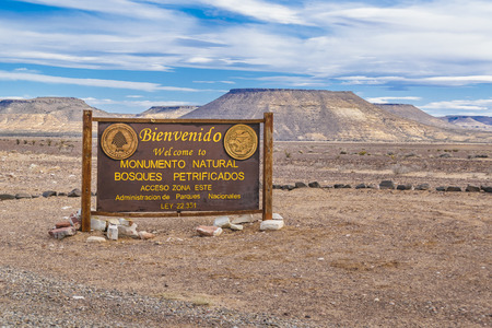 Wooden signpost with spanish text "Welcome to Petrified Forest National Monument" at entrance of petrified forest national park, Argentinaのeditorial素材