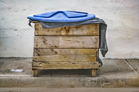 Front view of wooden trash can at sidewalkの写真素材