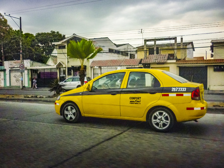 GUAYAQUIL, ECUADOR, DECEMBER - 2016 - Urban scene at street with yellow taxi car as main subject, Guayaquil, Ecuadorのeditorial素材
