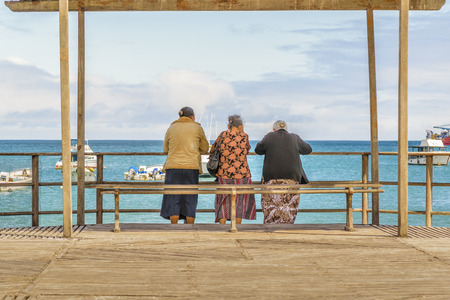 Back view seniors women watching the ocean at San Cristobal boardwalk, Galapagos, Ecuadorのeditorial素材