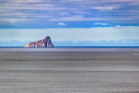 Distant view of famous leon dormido rock at middle of pacific ocean near Galapagos Islands, Ecuador