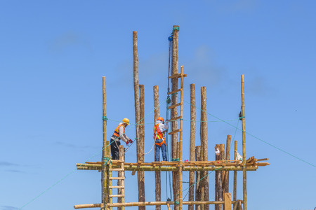 GALAPAGOS, ECUADOR - AUGUST - 2016 - Low angle view of a group of construction workers at top of...