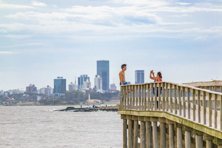 MONTEVIDEO, URUGUAY, JANUARY - 2016 - People at wooden walkway viewpoint near beach at punta gorda neighborhood, Montevideo, Uruguayのeditorial素材