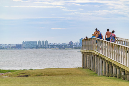 MONTEVIDEO, URUGUAY, JANUARY - 2016 - People at wooden walkway viewpoint near beach at punta gorda neighborhood, Montevideo, Uruguayのeditorial素材