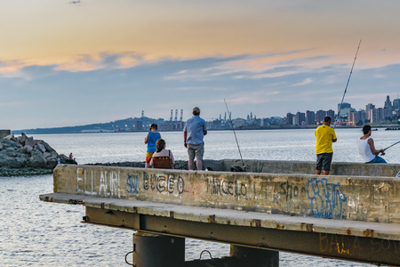 MONTEVIDEO, URUGUAY, JANUARY - 2016 - People fishing at breakwater in the coast of river in Montevideo, Uruguayのeditorial素材