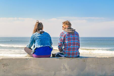PUNTA DEL ESTE, URUGUAY, AUGUST - 2016 - Back view of young adult couple watching the beach from...