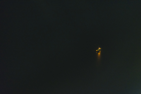 Aerial view night scene of commercial ship in the middle of seaの写真素材