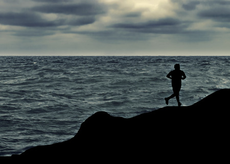 Man running at shore of ocean