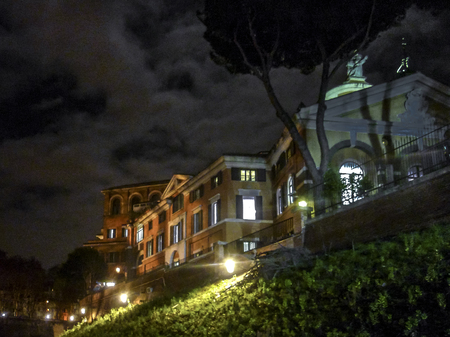 Urban night winter season scene with building at top of hill isola tiberina island in Rome city, Italyの写真素材