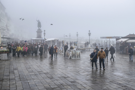 VENICE, ITALY, JANUARY - 2018 - Winter foggy urban scene with people walking at coastal street in venice city, Italyのeditorial素材