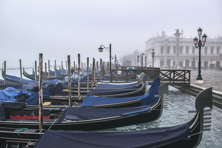 VENICE, ITALY, JANUARY - 2018 - Winter morning scene group of gondolas parked at shore in venice city, Italyのeditorial素材