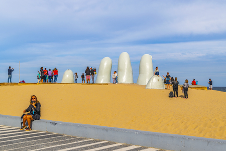 PUNTA DEL ESTE, URUGUAY, OCTOBER - 2018 -  Tourist at most famous landmark monument located at la brava beach in punta del este city, Uruguayのeditorial素材