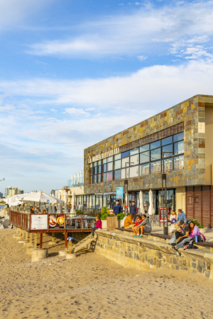 PUNTA DEL ESTE, URUGUAY, OCTOBER - 2018 - People at sunny winter scene at small port beach in punta del este city, Uruguayのeditorial素材