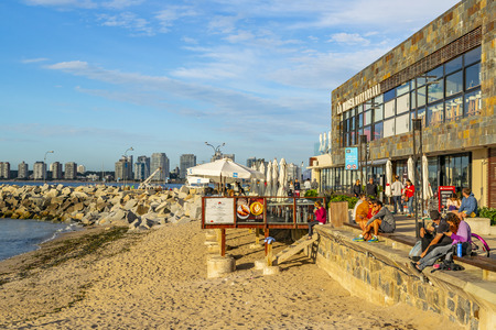 PUNTA DEL ESTE, URUGUAY, OCTOBER - 2018 - People at sunny winter scene at small port beach in punta del este city, Uruguayのeditorial素材
