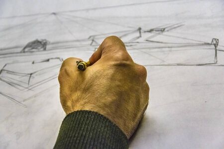 Interior scene of adult artist sketching his next artwork at workshopの写真素材