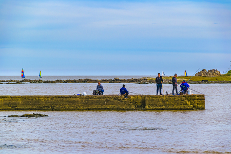MONTEVIDEO, URUGUAY, MAY - 2019 - Winter nature scene with people fishing at breakwater in malvin beach, montevideo, uruguayのeditorial素材