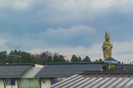 KYOTO, JAPAN, JANUARY - 2019 - Golden buddha sculpture view from train window at kyoto outskirt, japanのeditorial素材