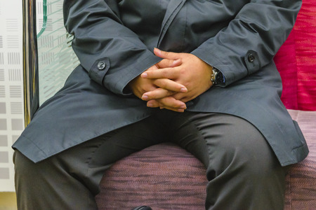 KYOTO, JAPAN, JANUARY - 2019 - Detail view of hands and part of body of fat man sitting at train seat, kyoto prefecture, japanのeditorial素材