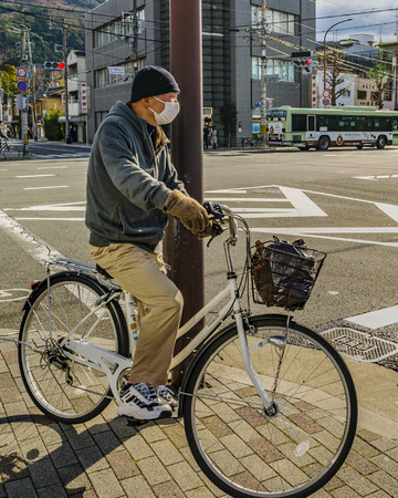 KYOTO, JAPAN, JANUARY - 2019 - Adult man at bicycle riding at street at modern zone of kyoto city, japanのeditorial素材