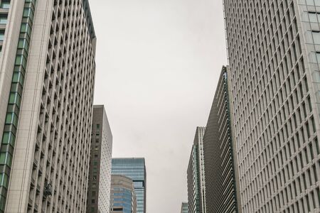 Low angle perspective view of modern tall buildings at chiyoda district in tokyo city, japanの写真素材
