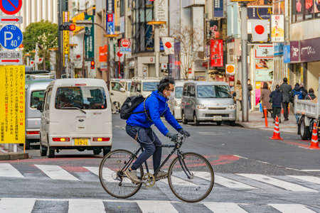 TOKYO, JAPAN, JANUARY - 2019 - Man crossing the street at bicycle in famous shibuya district in tokyo city, japanのeditorial素材