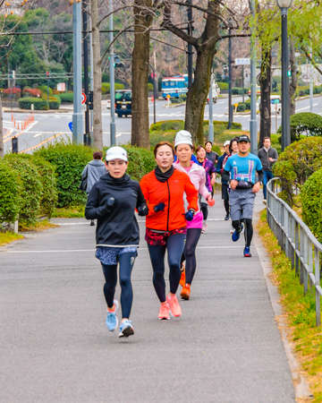 TOKYO, JAPAN, JANUARY - 2019 - People running at exterior imperial palace park in chiyoda district,...