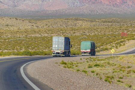 MENDOZA, ARGENTINA, APRIL - 2019 - Two cargo trucks driving at andean highway at mendoza province, argentinaの写真素材