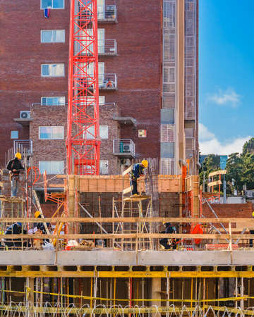 MONTEVIDEO, URUGUAY, JULY - 2020 - Workers working on a building construction site, montevideo, uruguayのeditorial素材