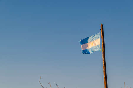 Argentina flag flaming over clean blue skyの写真素材