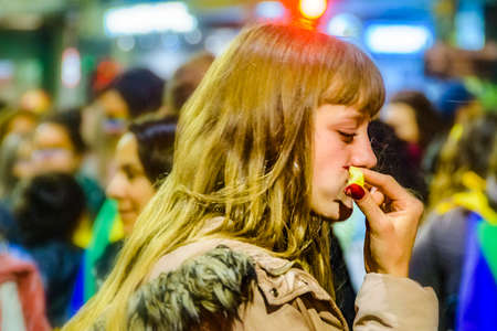 MONTEVIDEO, URUGUAY, SEPTEMBER - 2020 - Blonde young woman eatinf at diversity parade celebration,...