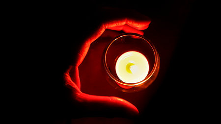 Top view shot hand covering candle on glass